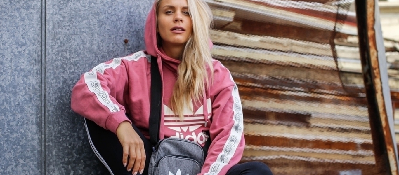 Kuvassa on Eevi Teittinen päällään adidas Originals huppari sekä adidas Originals laukku.